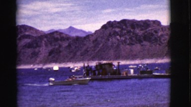 1968: a small metal motor boat traveling in the water towards the shoreline