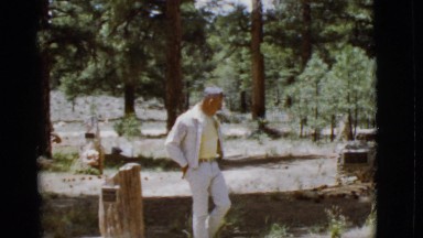 1968: a man walking between the gravestones of a poorly care cemetery