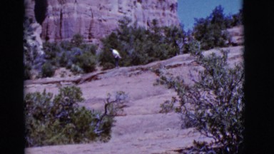 1968: person dancing alone on a rock surface at the foot of a mountain range