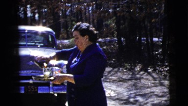 1956: woman holding a tray in front of car pours drinks