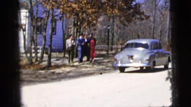 1956: group of well-dressed individuals make slow progress towards street