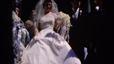 1962: newly wed couple leaves church walking past friends and family tossing