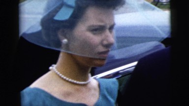 1962: well dressed woman in blue with white pearls taking in group NEW YORK CITY