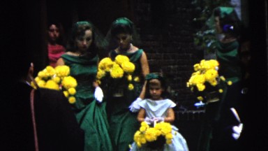 1962: bridesmaids in green and pink dresses and white gloves carrying bouquets