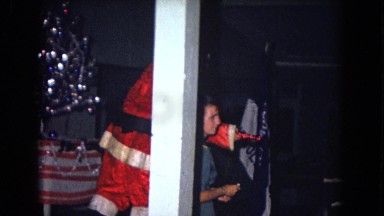1967: santa visits a large room of people of all ages and passes a present
