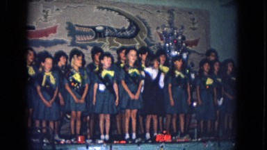 1967: girls in uniforms and sashes sing together on stage