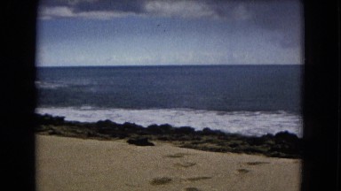 1967: beachside view with hills in the background and water crashing