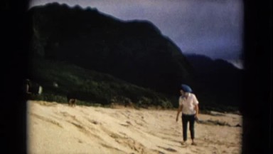 1967: a woman with two young girls and a pet walking on the beach NEVADA