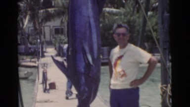 1956: men on a wooden fishing dock inspecting their large catch of the day