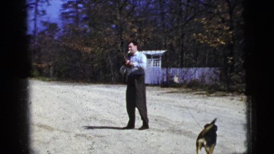 1956: a man smoking a cigarette plays catch while a dog watches FLORIDA