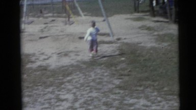 1967: two kids are hurry to grab the swing in the park. CAMDEN, NEW JERSEY
