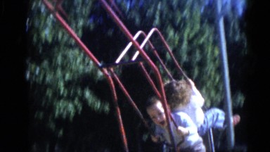 1956: Two Kids Swinging on a Swing Set in a Park in Camden, Florida