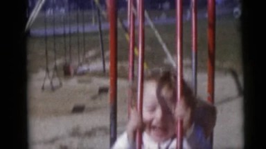 1967: two beautiful swinging boys in a park with full of sunlight CAMDEN
