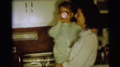 1954: the mother in the kitchen with kid on the hip drinking PENNINGTON