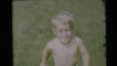 1954: a very happy toddler boy is running as fast as he can with only shorts
