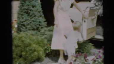 1954: a small child climbs on his own within a motor vehicle observed by a woman