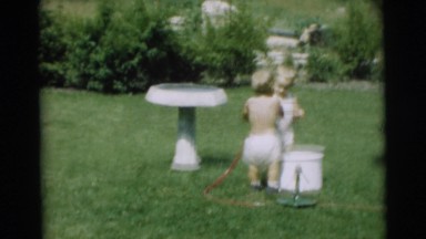 1967: little children in yard playing with garden hose outside CAMDEN