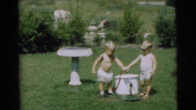 1967: two kids playing with watering hose on the lawn CAMDEN, NEW JERSEY