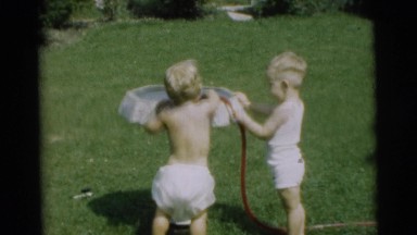 1954: the childrens are playing with water in green fields PENNINGTON