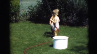 1967: two blond toddlers playing with hose in garden CAMDEN, NEW JERSEY