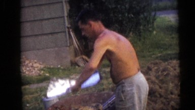 1954: Shirtless Man Folding Aluminum Foil for Fire Pit Cookout in Pennington, NJ