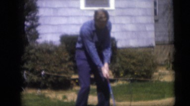 1967: Young Man in Blue Swings Golf Club in Camden, New Jersey Backyard