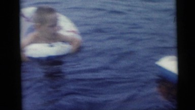 1967: two children swim with an inflatable ring while two women supervise