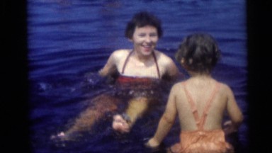 1954: Mother Enjoying Water with Rubber Ring and Playing with Child
