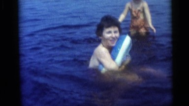 1954: Woman and Toddler Play in Shallow Lake with Inflatable Ring