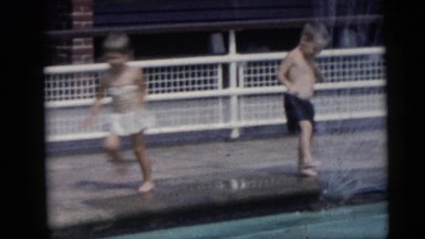 1967: Young Children in Swimsuits Frolic, Run, and Play Around Pool