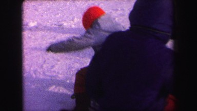 1972: bundled kids playing on a traditional sled in the winter snow LYNBROOK