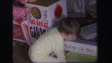 1972: excited children at christmas time getting their presents to open them.