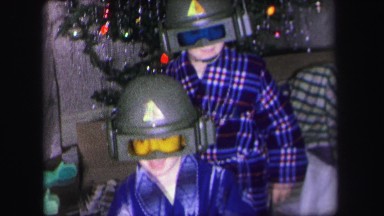 1972: boys in pajamas admire new military costume helmets with family near
