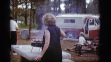 1968: a woman in the park cooking dinner on a portable grill COTTONWOOD, ARIZONA