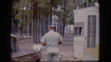1968: bald headed old man is closing the door of a cabin in the woods