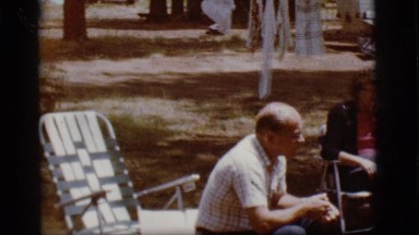 1968: three persons sitting and having a talk outside a vehicle COTTONWOOD,
