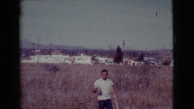 1968: a black dog with it's master in a playing mood in outskirts of a city