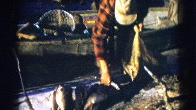1953: the man puts fishes into the thread bag WISCONSIN
