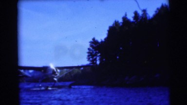 1953: seaplane drifts along blue river near shore WISCONSIN