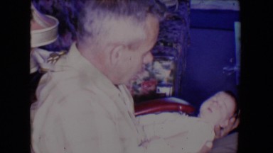 1961: older man handles infant SALTON SEA, CALIFORNIA