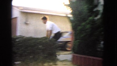 1966: funny scene of young man lugging extra heavy parcel down front steps