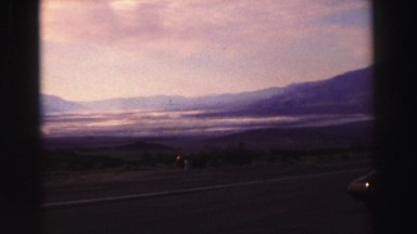 1969: view of mountains from the side of road with car YOSEMITE, CALIFORNIA