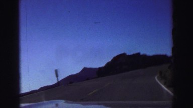 1969: driving on highway with the horizon and mountains in the distance