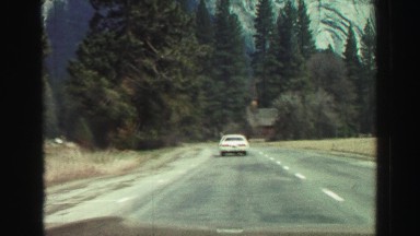 1969: car is moving through the road in the valley of a mountain YOSEMITE,