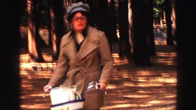 1969: in the woods a lady riding on bicycle and people walk YOSEMITE, CALIFORNIA