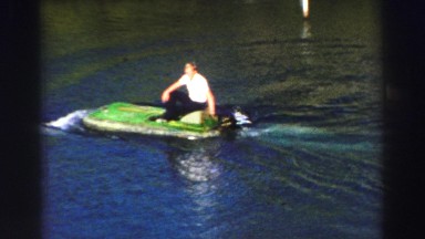 1969: a dolphin swimming in the water next to a man at a water park attraction