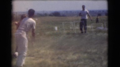 1951: a group of young men outdoors playing baseball in a large empty field.