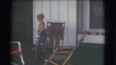 1951: a little boy walking through the courtyard of a house and trying to climb