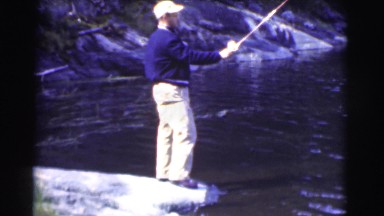 1951: a man on the shore of a beautiful lake fishing CANADA