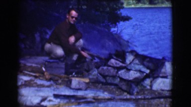1951: camping nature while trying to create a fire with old fashion styled